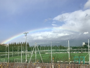 いさりび鉄道から見た虹とサッカー場の写真