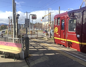 清川口駅から出発する濃赤車両の写真