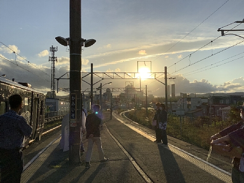 ながまれ海峡号ツアー　上磯駅ホームから見た夕日が差す太平洋セメント工場の写真